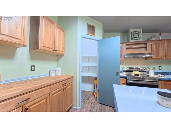 a kitchen with kitchen island a sink a stove and cabinets
