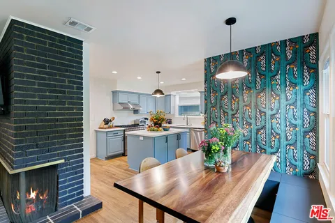 a kitchen with a stove a sink dishwasher and a refrigerator with wooden floor