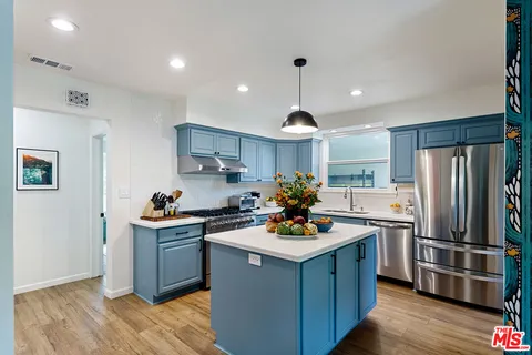 a view of kitchen island with wooden floor and living room