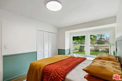 a bedroom with bed table and window