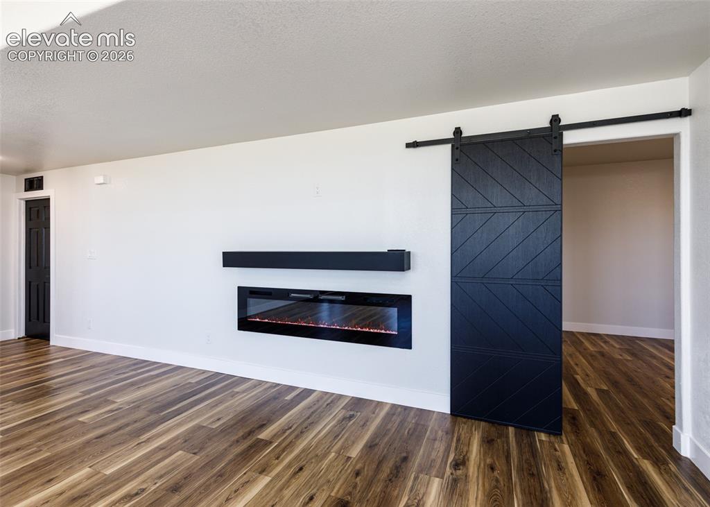 1120 Newton Road Pueblo, CO 81005 - Photo 26 of 46 a view of an empty room with wooden floor and a fireplace