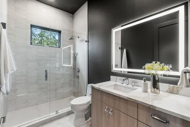a bathroom with a double vanity sink toilet and shower