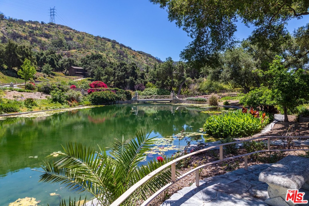 3100 Mandeville Canyon Road Los Angeles, CA 90049 - Photo 12 of 27 a view of a lake with a house in the background