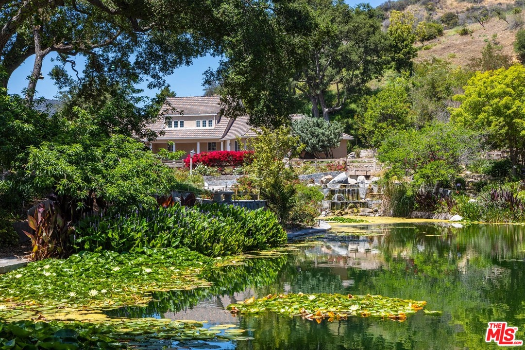 3100 Mandeville Canyon Road Los Angeles, CA 90049 - Photo 13 of 27 a view of a house with a yard and potted plants