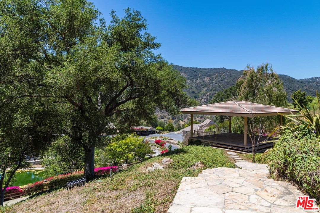 3100 Mandeville Canyon Road Los Angeles, CA 90049 - Photo 16 of 27 a view of a patio with furniture and a garden