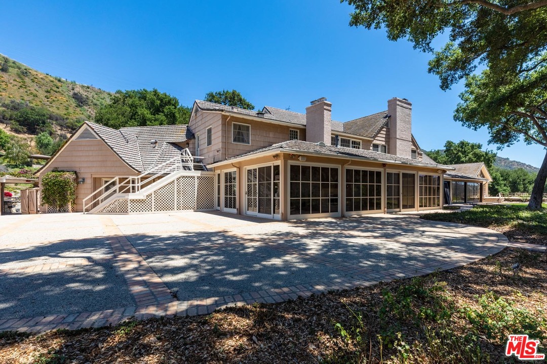 3100 Mandeville Canyon Road Los Angeles, CA 90049 - Photo 20 of 27 a front view of a house with a yard
