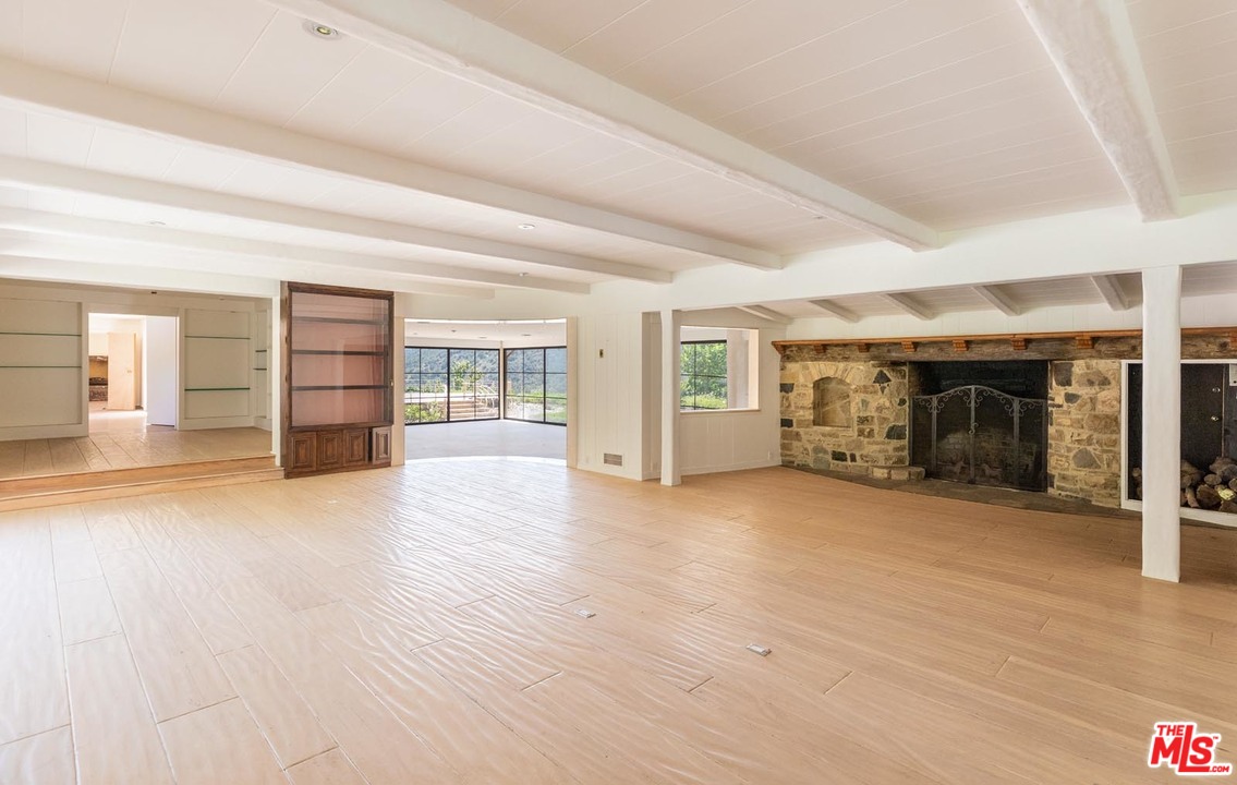 3100 Mandeville Canyon Road Los Angeles, CA 90049 - Photo 24 of 27 an empty room with furniture and a fireplace
