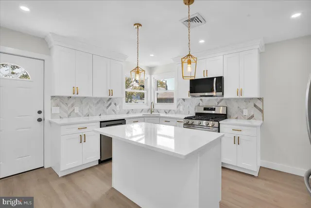 a kitchen with white cabinets and appliances