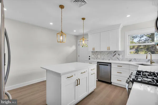 a kitchen that has a sink a stove and a wooden floor