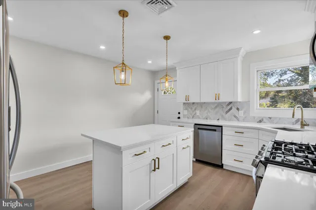 a kitchen that has a sink a stove and a wooden floor