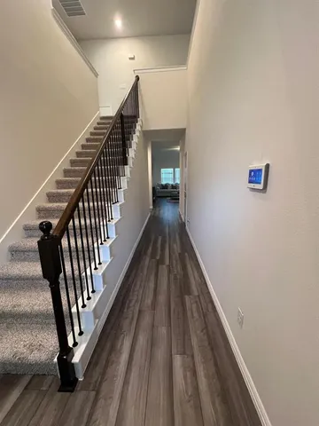a view of a hallway with wooden floor and stairs