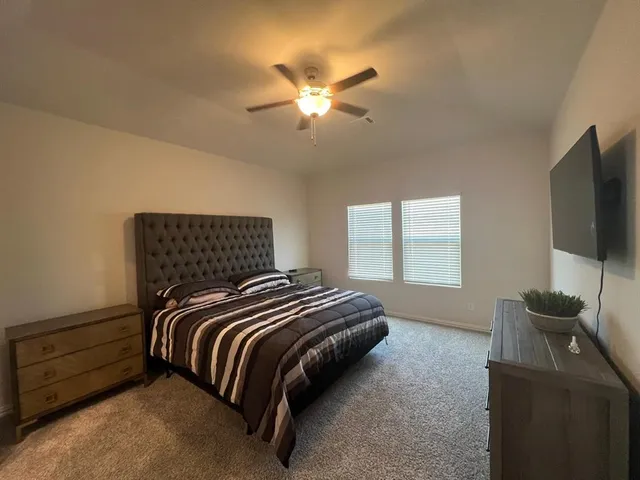 a bedroom with a bed and a flat screen tv