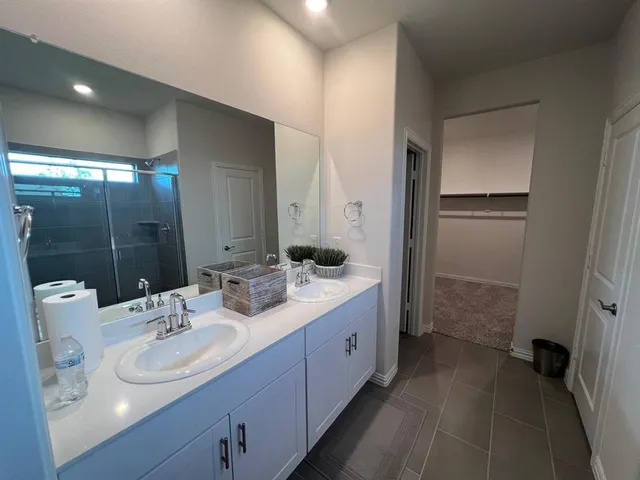 a bathroom with a double vanity sink mirror and shower