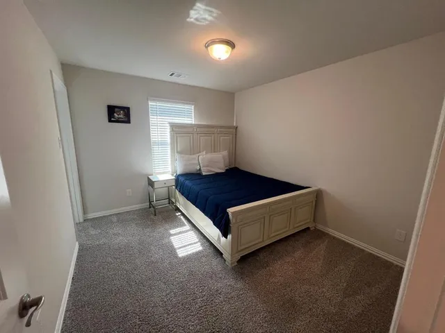 a spacious bedroom with a bed and a window