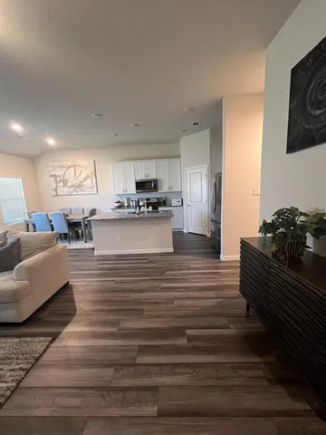 a living room with kitchen island furniture and a wooden floor
