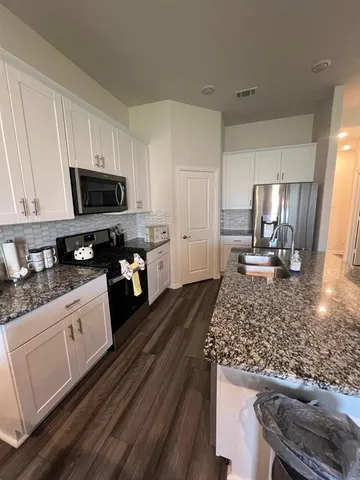 a kitchen with a stove a sink and a microwave