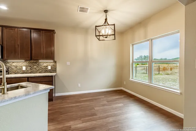 a view of empty room with wooden floor and window