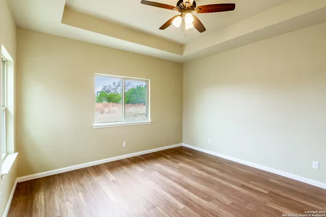 an empty room with a window and a ceiling fan