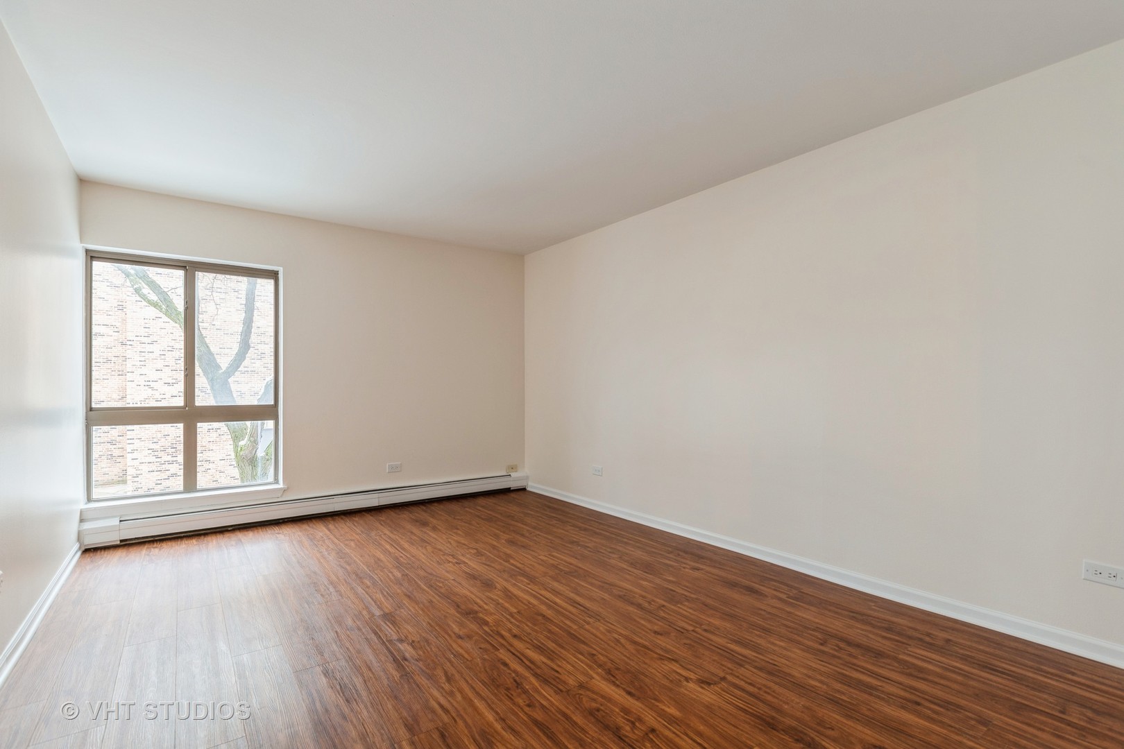 1919 Prairie Square, Unit 133 Schaumburg, IL 60173 - Photo 11 of 14 an empty room with wooden floor and windows