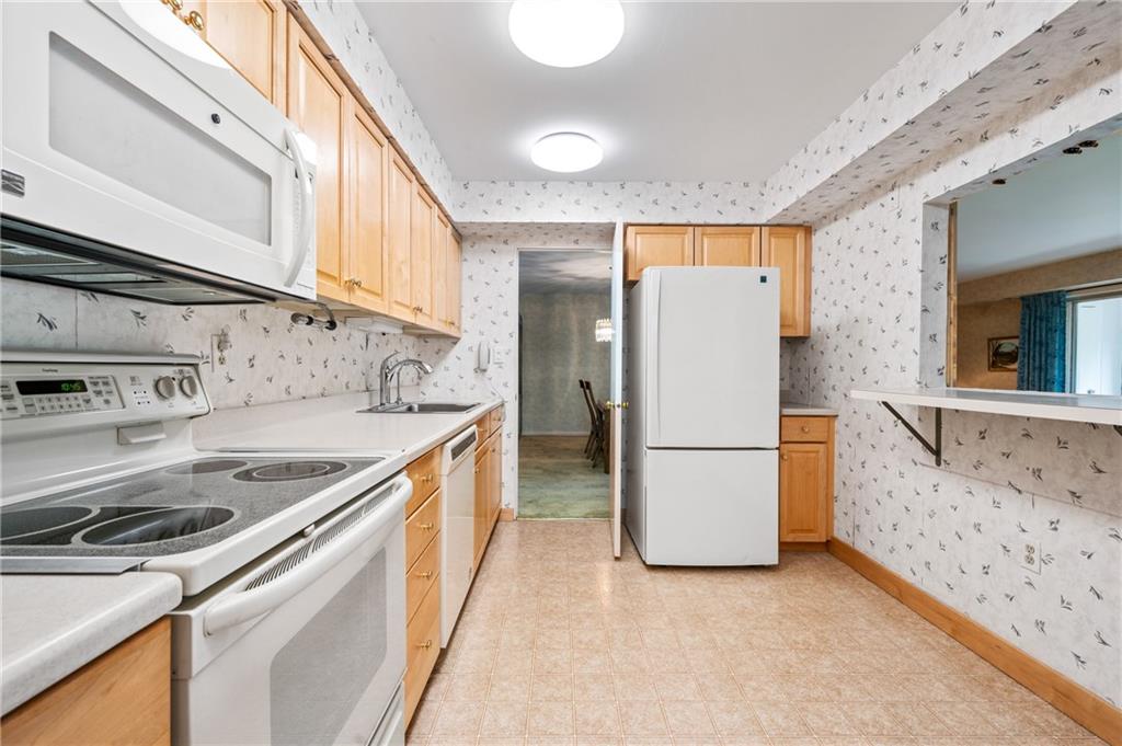 302 Fox Chapel Road, Unit 401 Pittsburgh, PA 15238 - Photo 6 of 25 a kitchen with a sink a refrigerator and a stove top oven
