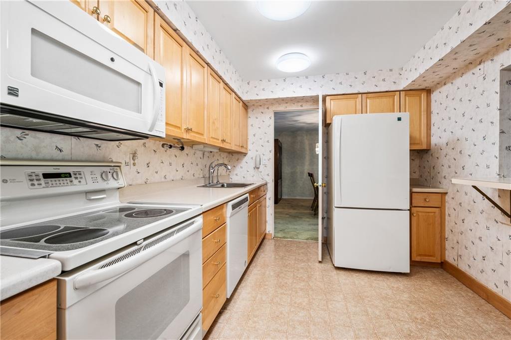 302 Fox Chapel Road, Unit 401 Pittsburgh, PA 15238 - Photo 7 of 25 a kitchen with a refrigerator a stove top oven and a counter space