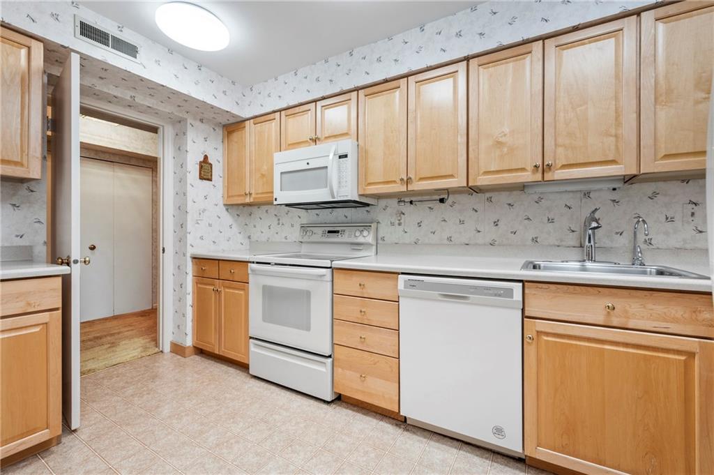 302 Fox Chapel Road, Unit 401 Pittsburgh, PA 15238 - Photo 9 of 25 a kitchen with granite countertop white cabinets and sink