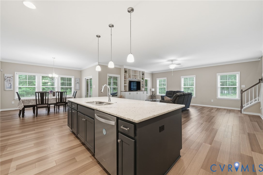 7598 Rural Point Road Mechanicsville, VA 23116 - Photo 15 of 41 a large kitchen with kitchen island a stove a sink a dining table and chairs with wooden floor