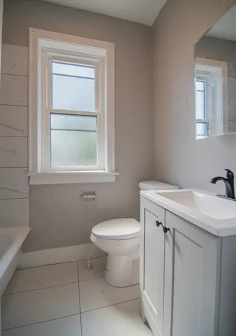 a bathroom with a sink toilet and window