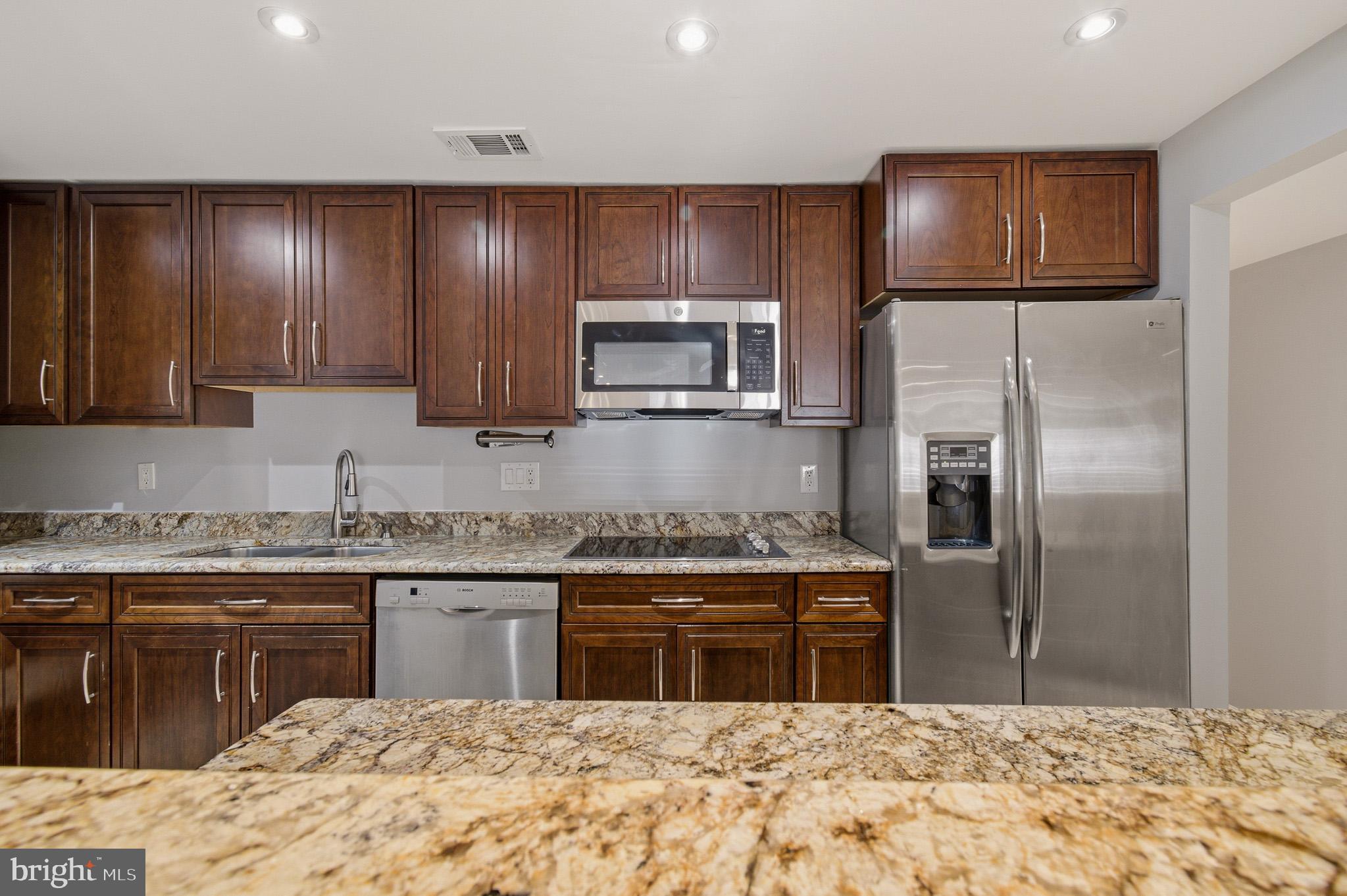 2117 S Street Northwest Washington, DC 20008 - Photo 35 of 63 a kitchen with stainless steel appliances granite countertop a stove a sink and a refrigerator