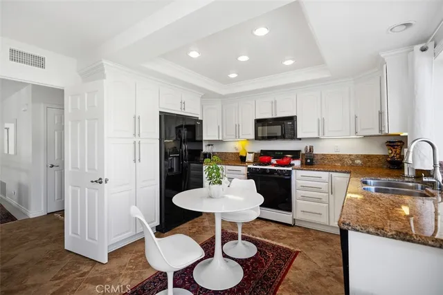 a kitchen with stainless steel appliances granite countertop a refrigerator and a stove