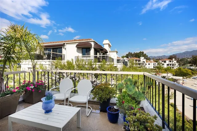 a view of a balcony with chairs and potted plants
