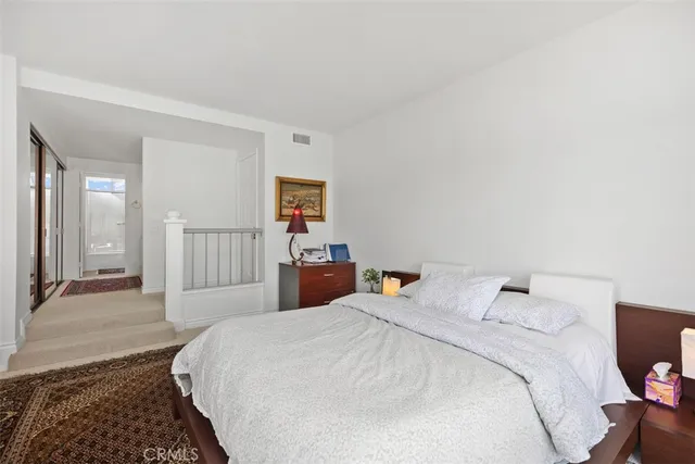 a large bed in a white room with closet