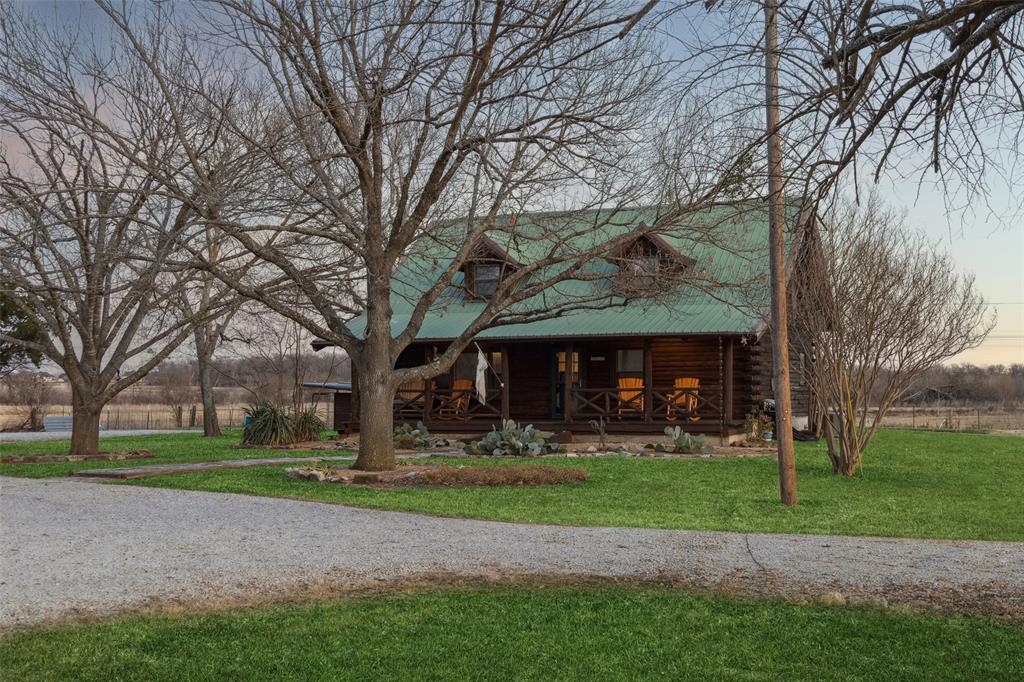 a front view of a house with garden and trees