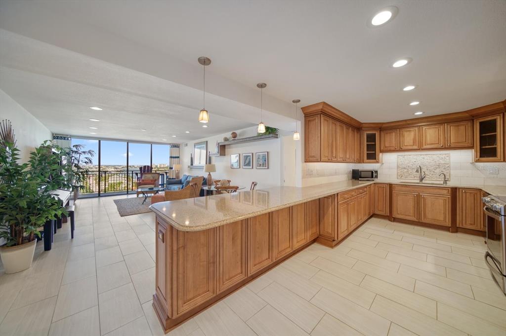 a large white kitchen with kitchen island a sink a counter top space and a center island