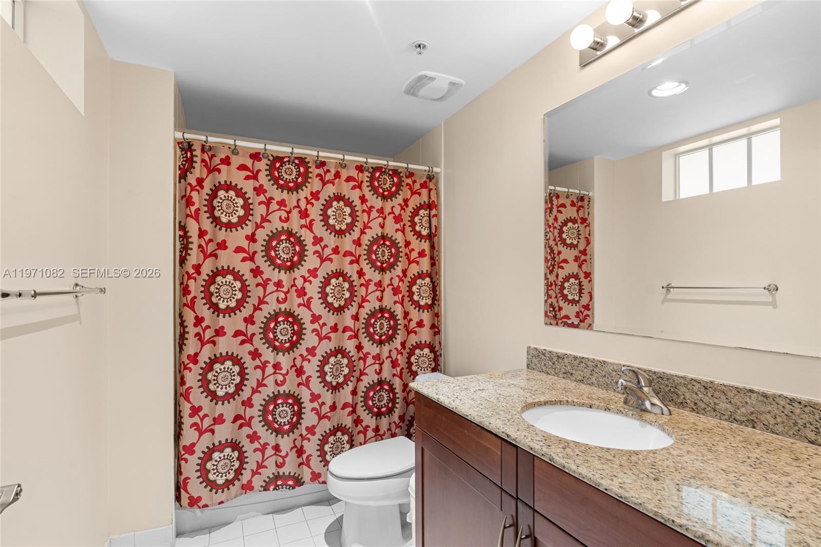 7275 Southwest 90th Way, Unit 404 Miami, FL 33156 - Photo 16 of 35 a bathroom with a granite countertop toilet a sink and a mirror