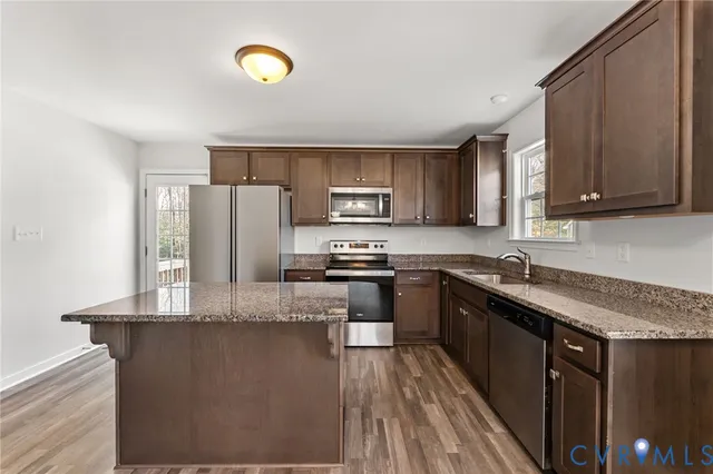 a kitchen with stainless steel appliances granite countertop a stove a sink dishwasher and a refrigerator