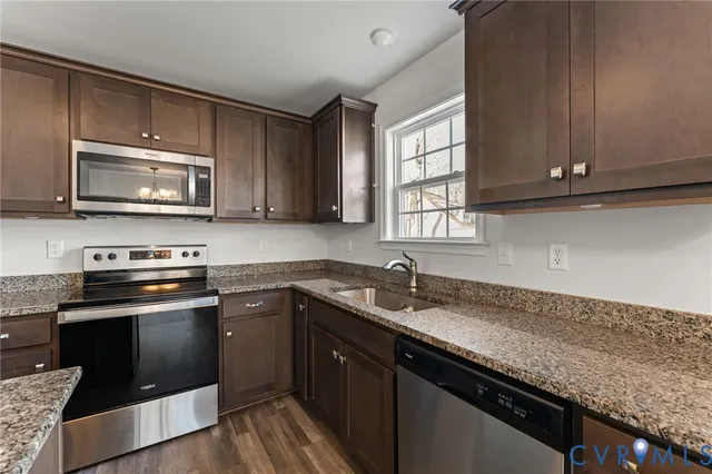 a kitchen with granite countertop cabinets stainless steel appliances a sink and window