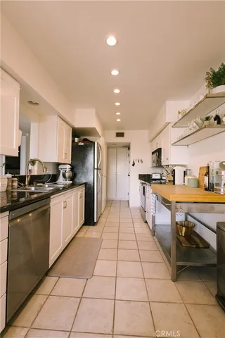 a large kitchen with kitchen island granite countertop a stove a sink dishwasher and a refrigerator