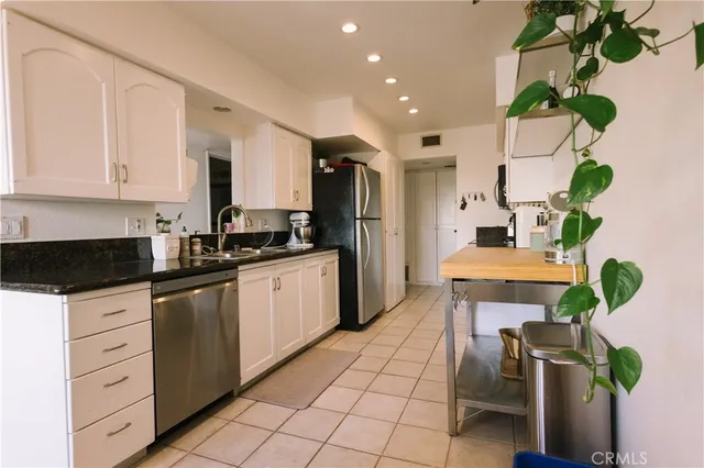 a kitchen with granite countertop a white cabinets stainless steel appliances and a counter top