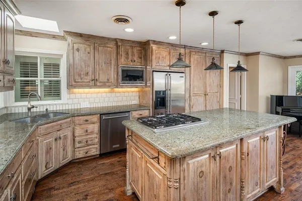 a kitchen with a stove a sink a refrigerator and wooden cabinets