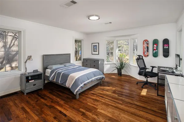 a bedroom with a bed and wooden floor