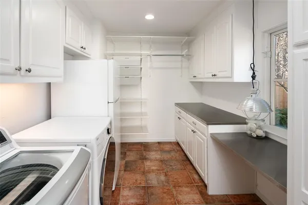 a kitchen with a refrigerator and white cabinets