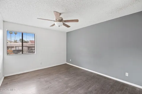 an empty room with a window and ceiling fan