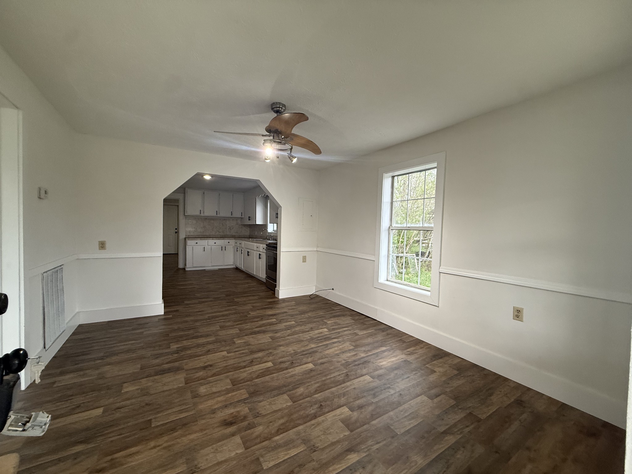 209 West 3rd Avenue Hohenwald, TN 38462 - Photo 5 of 12 an empty room with wooden floor fan and windows
