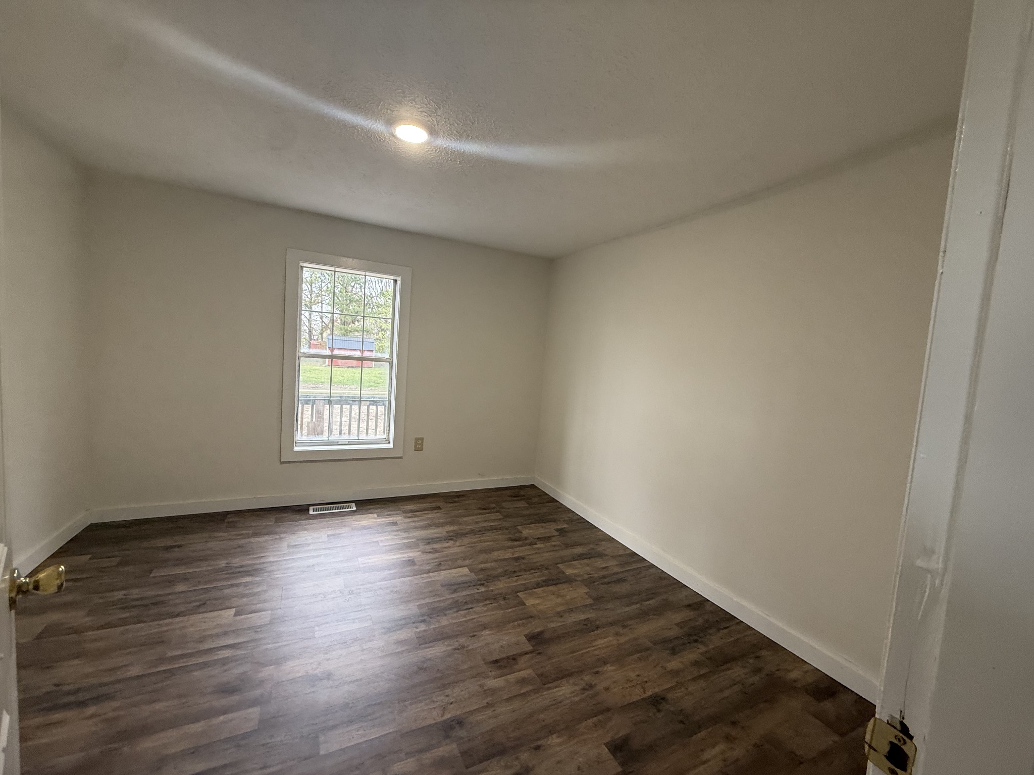 209 West 3rd Avenue Hohenwald, TN 38462 - Photo 9 of 12 an empty room with wooden floor and windows
