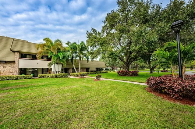 a view of a big house with a big yard and large trees
