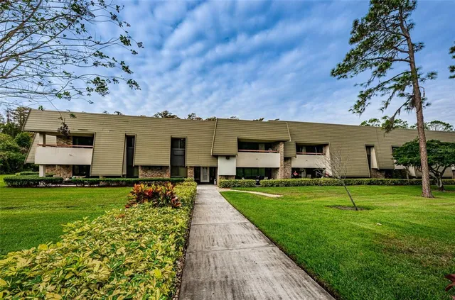 a front view of a house with a garden and trees