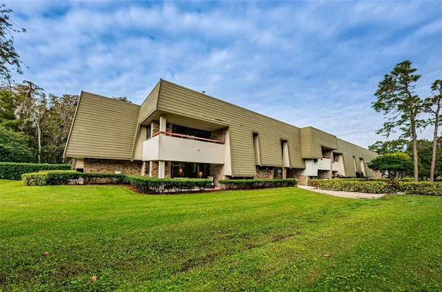 a view of a house with a big yard and sitting area