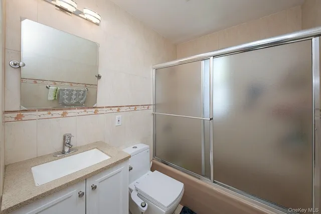 a bathroom with a sink mirror vanity and toilet