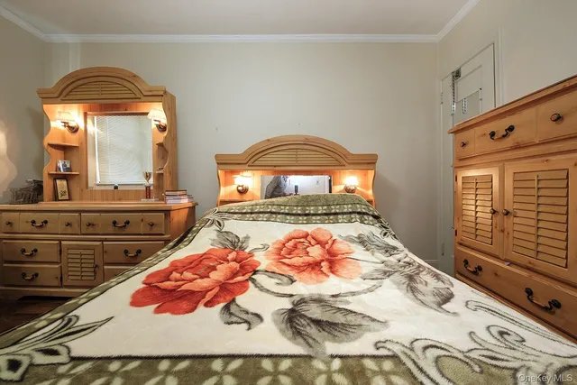 a bedroom with a bed and a mirror on dresser
